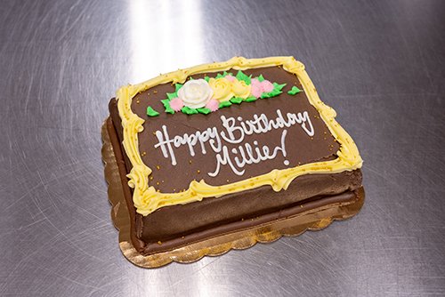 a freshly baked cake that is hand frosted and decorated for a birthday